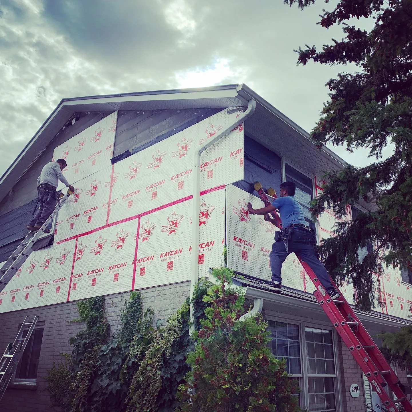 Crew installing siding and capping